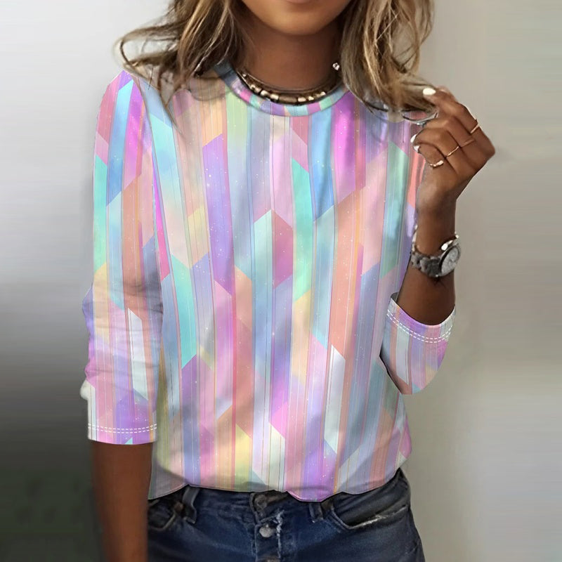 Woman in striped top, heart necklace, white pants.
