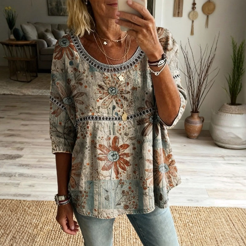 Woman in striped top, heart necklace, white pants.